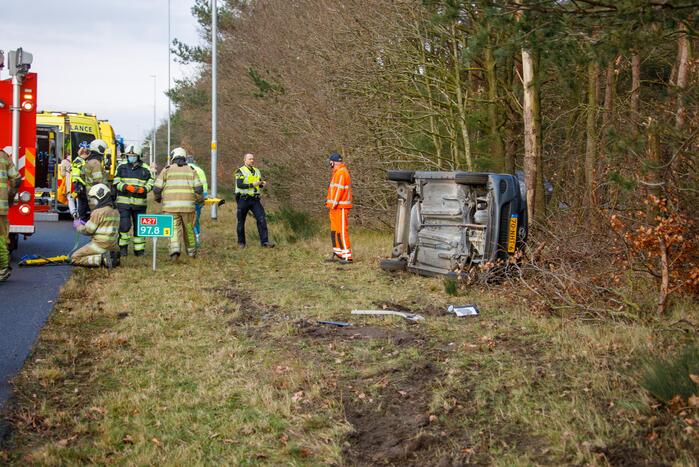 Auto vliegt uit de bocht en belandt op zijn kant