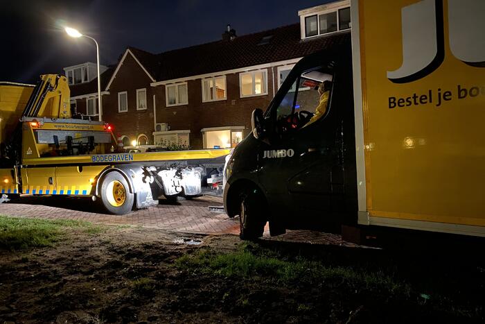 Jumbo-bezorgbus rijdt zich vast in berm