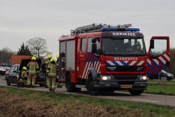 Rook onder motorkap van rijdende auto