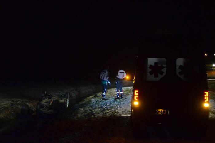 Auto glijdt van de weg en belandt op de kop in sloot