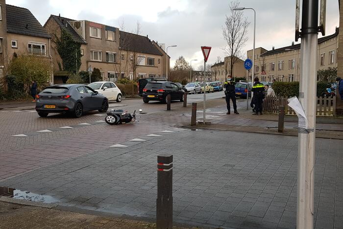 Personenauto en scooter met elkaar in aanrijding