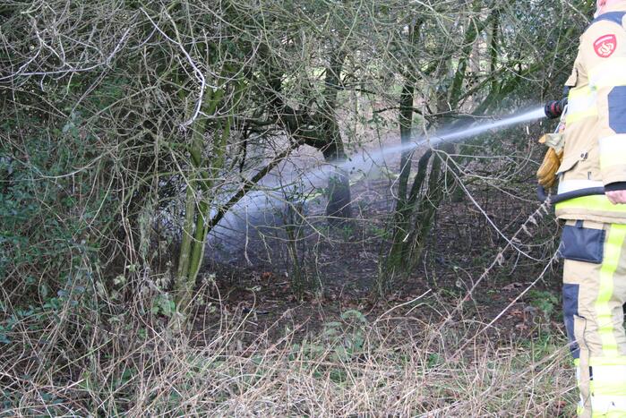 Brandweer blust autoband in bos