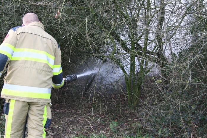 Brandweer blust autoband in bos
