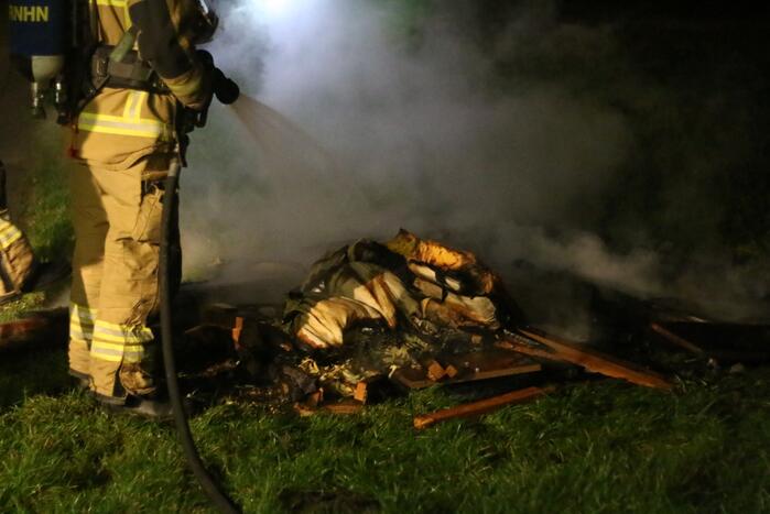Brandweer blust brandende matras en pallets