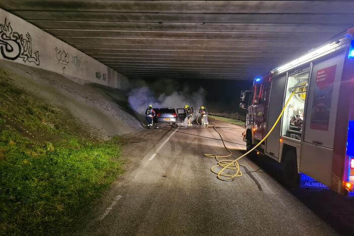 Auto vat vlam onder viaduct snelweg