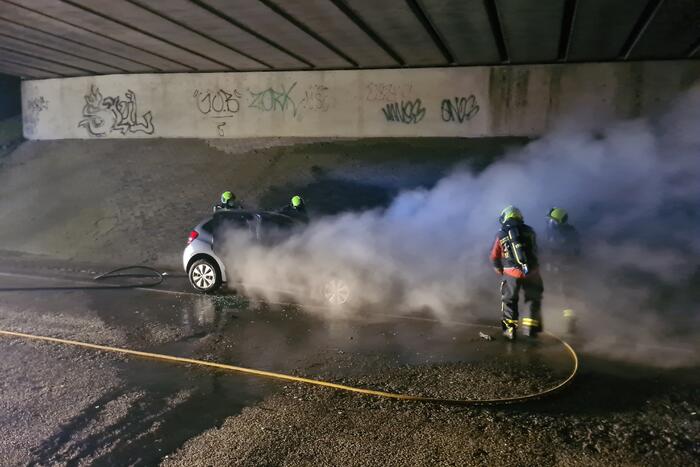 Auto vat vlam onder viaduct snelweg