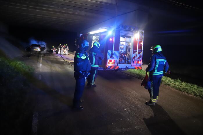 Auto vat vlam onder viaduct snelweg