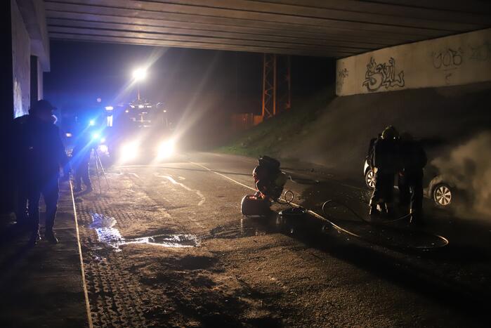 Auto vat vlam onder viaduct snelweg
