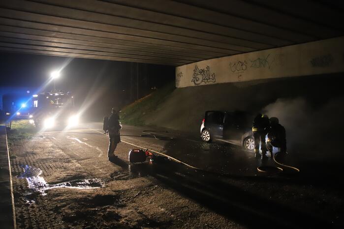 Auto vat vlam onder viaduct snelweg
