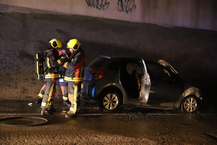 Auto vat vlam onder viaduct snelweg