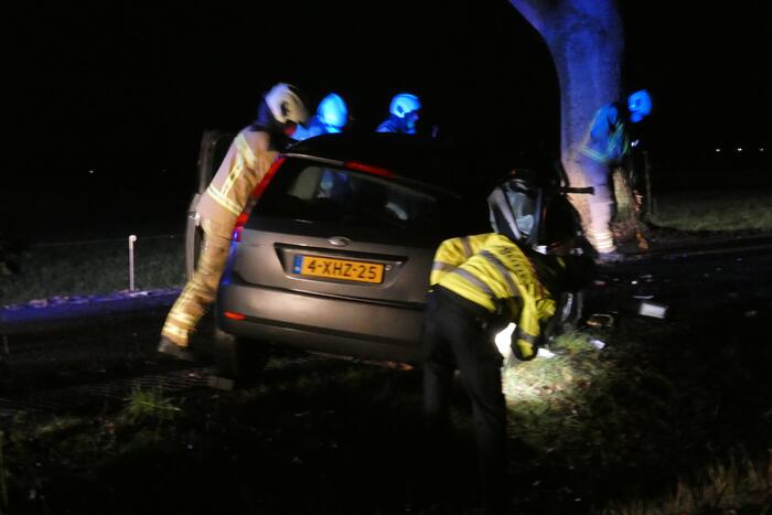 Auto klapt hard tegen boom