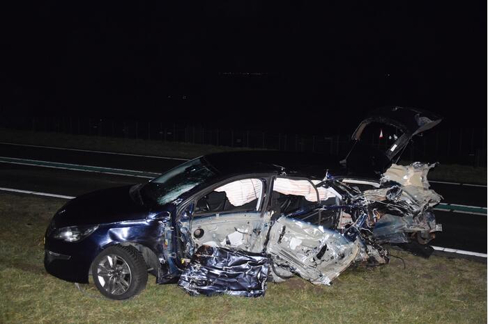 Bestelbus op de kop en auto doormidden