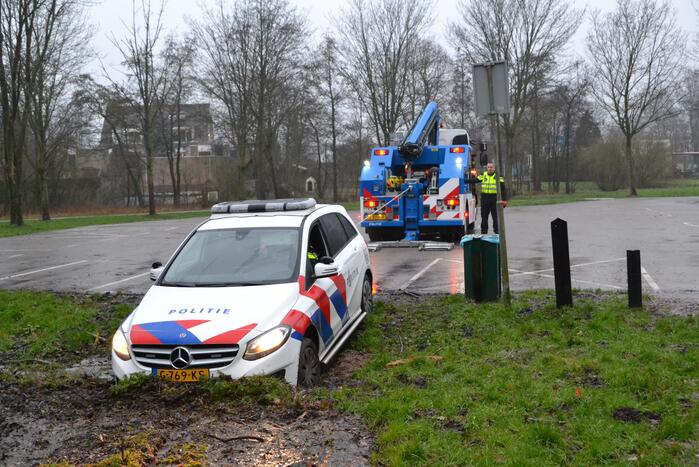 Politieauto rijdt zich vast in modder