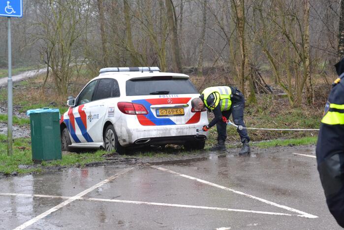 Politieauto rijdt zich vast in modder