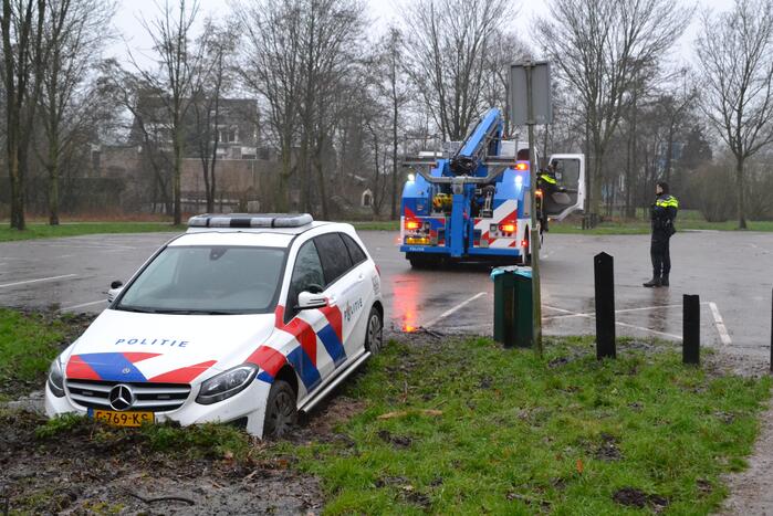 Politieauto rijdt zich vast in modder