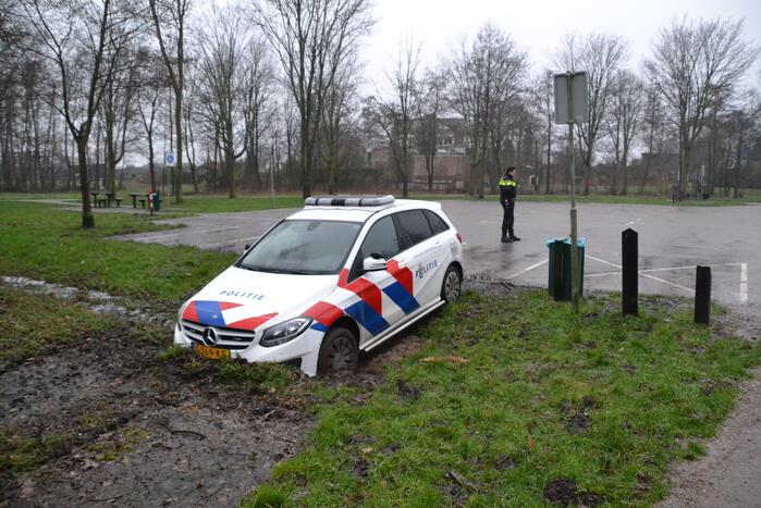 Politieauto rijdt zich vast in modder