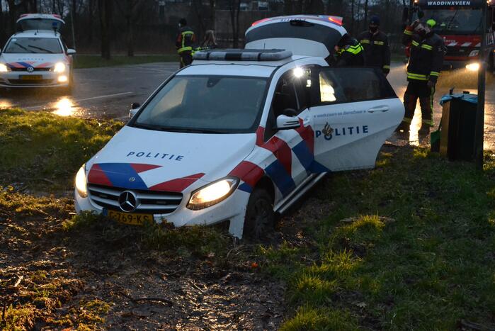 Politieauto rijdt zich vast in modder