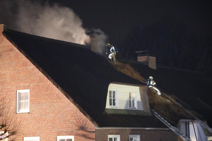 Brand in schoorsteen slaat over op rietenkap