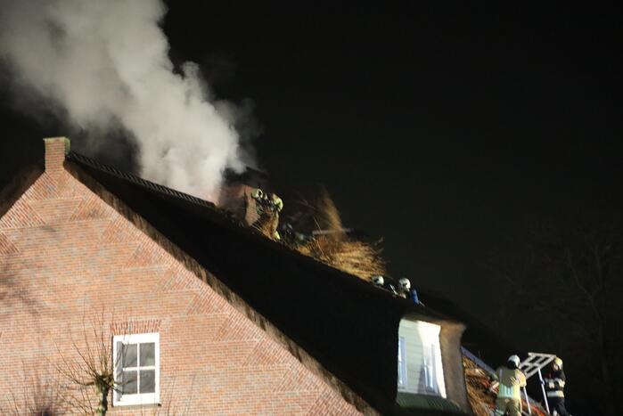 Brand in schoorsteen slaat over op rietenkap