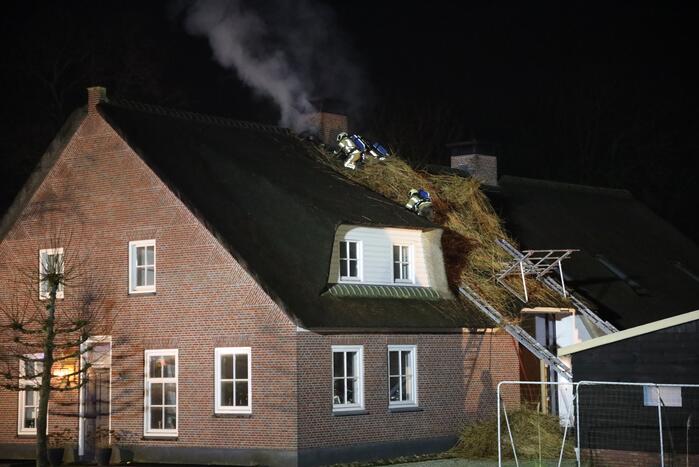 Brand in schoorsteen slaat over op rietenkap