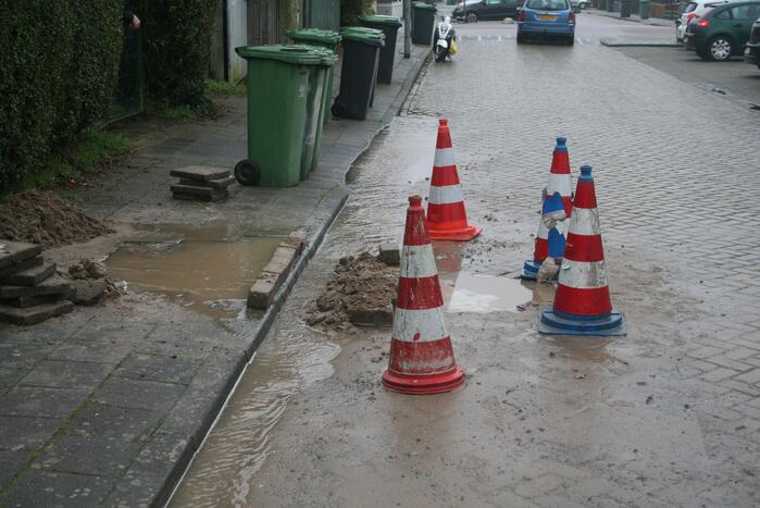 Gat in trottoir door gesprongen waterleiding