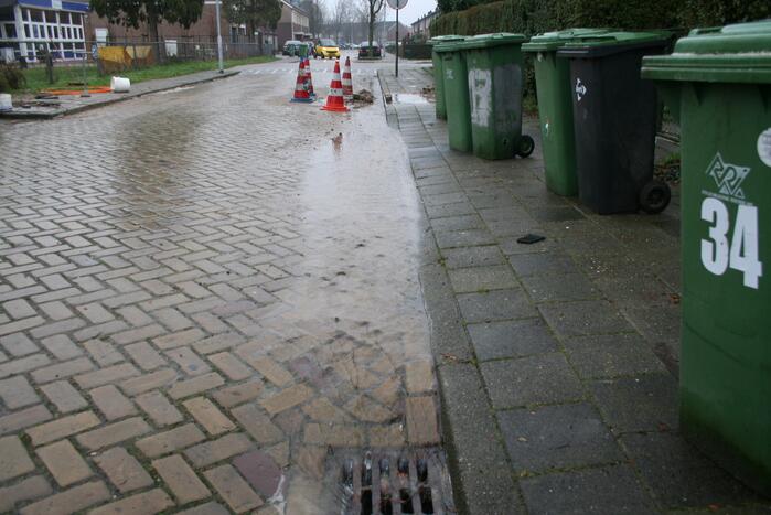Gat in trottoir door gesprongen waterleiding