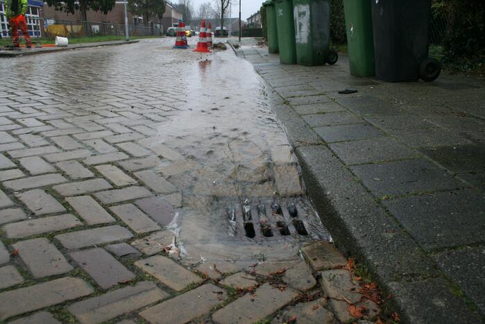 Gat in trottoir door gesprongen waterleiding