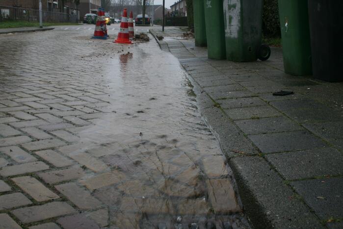 Gat in trottoir door gesprongen waterleiding