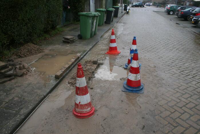 Gat in trottoir door gesprongen waterleiding