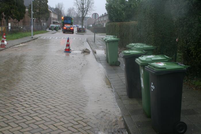 Gat in trottoir door gesprongen waterleiding