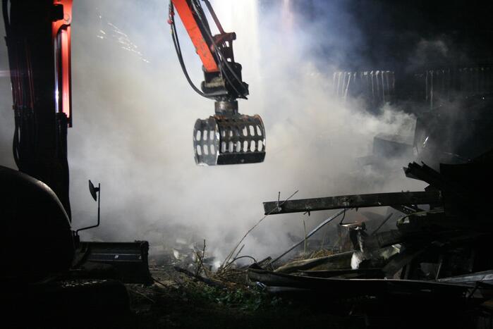 Grote uitslaande brand in loods achter woning