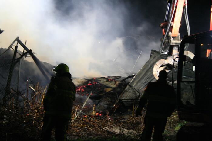 Grote uitslaande brand in loods achter woning