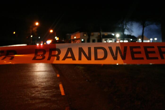 Grote uitslaande brand in loods achter woning