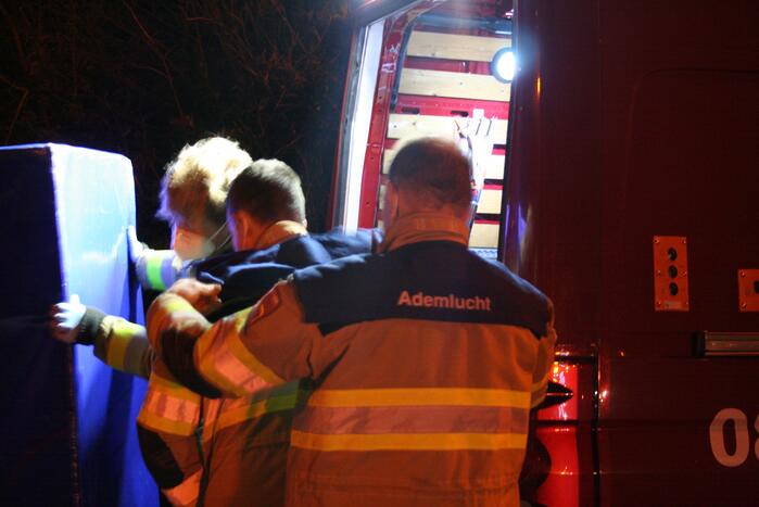 Grote uitslaande brand in loods achter woning