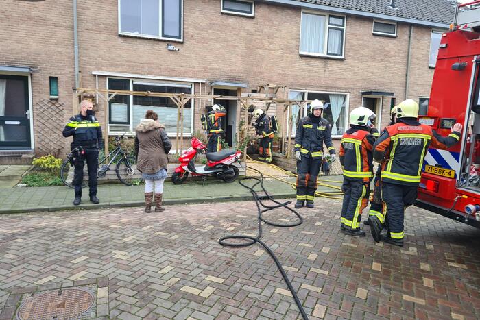 Kleding in woning vliegt in brand