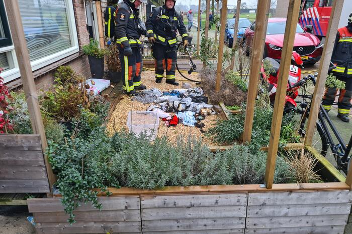 Kleding in woning vliegt in brand