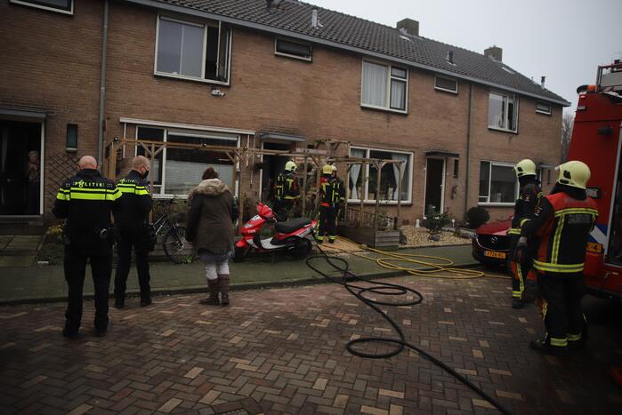 Kleding in woning vliegt in brand