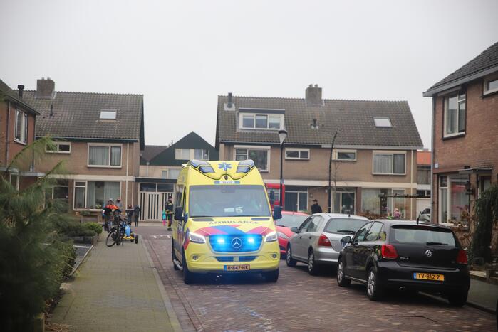 Kleding in woning vliegt in brand