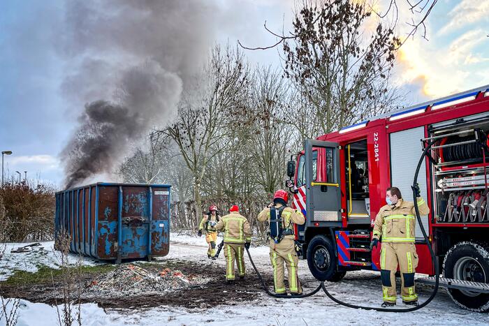 Felle brand in container met bouwafval