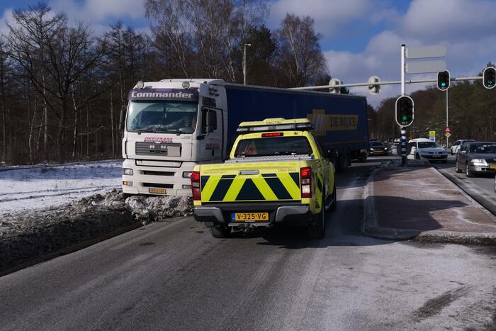 Vrachtwagen met oplegger vast in berm