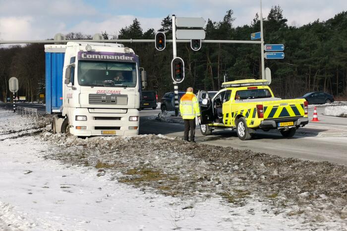 Vrachtwagen met oplegger vast in berm