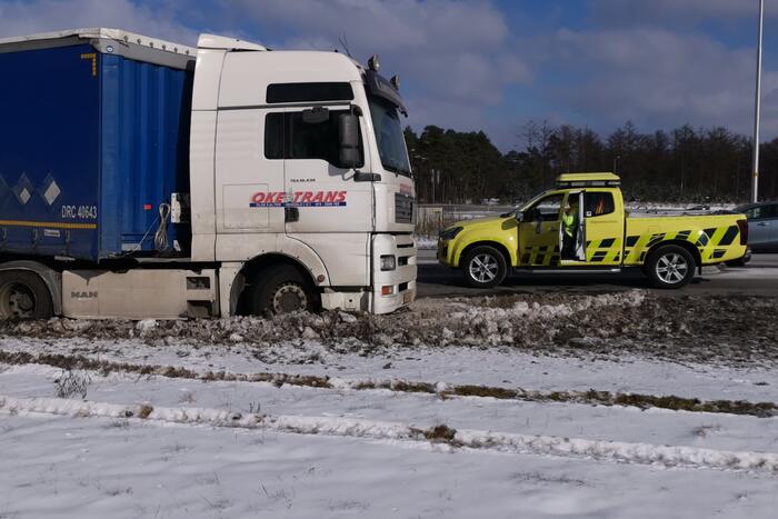 Vrachtwagen met oplegger vast in berm