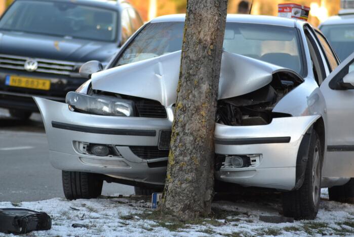 Personenauto klapt tegen boom