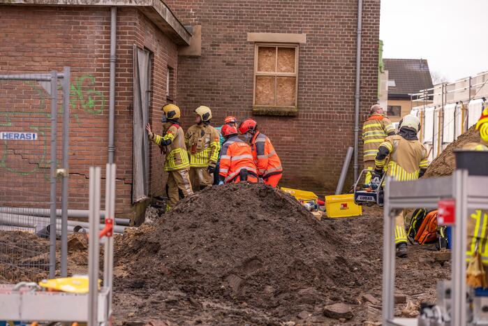 Persoon bekneld onder betonnen plaat