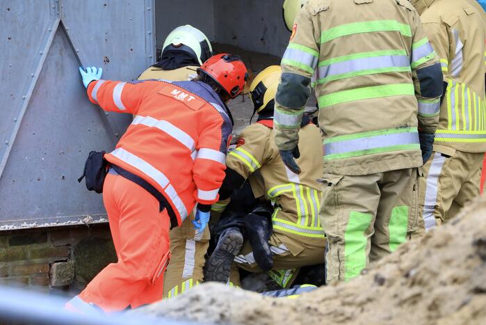 Persoon bekneld onder betonnen plaat