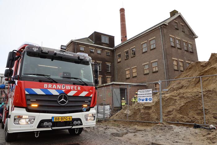 Persoon bekneld onder betonnen plaat