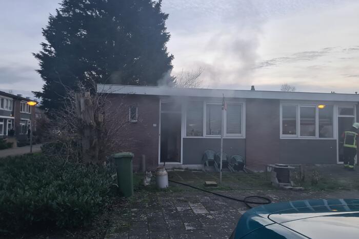 Brandweer blust brandende pan in woning