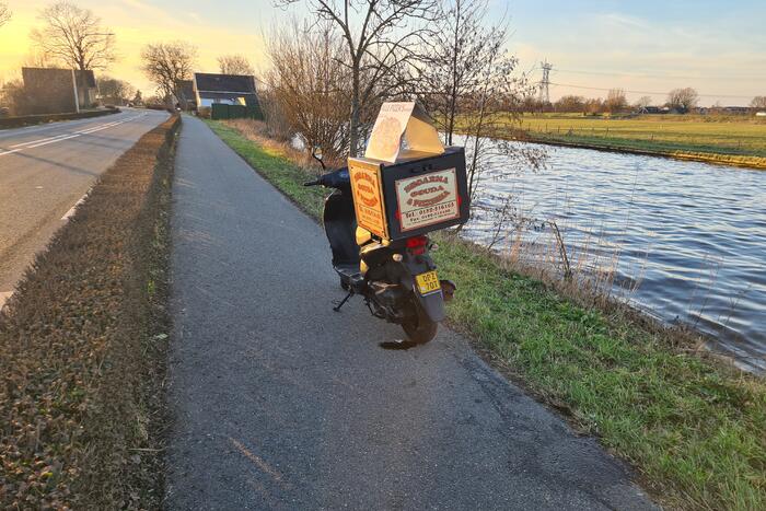 Bezorger met scooter onderuit
