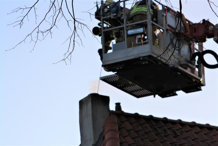 Brandweer veegt schoorsteen na brand