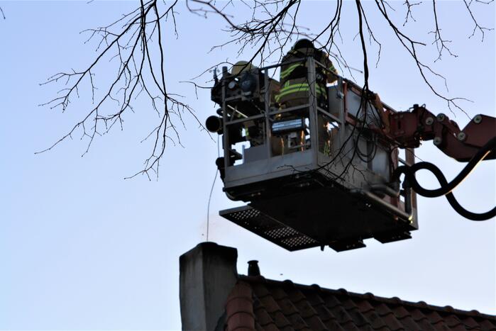 Brandweer veegt schoorsteen na brand